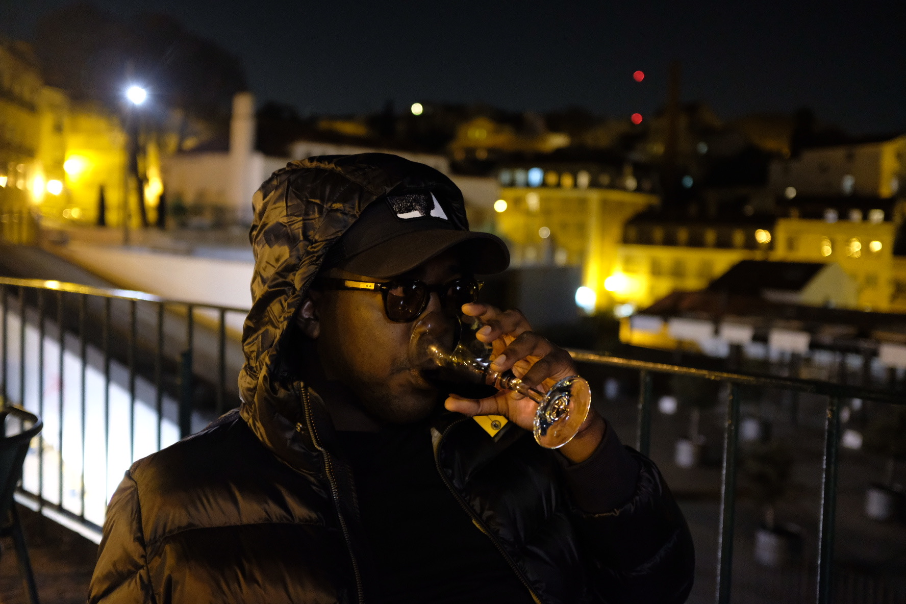 Alexander enjoying a drink at night overlooking Lisbon