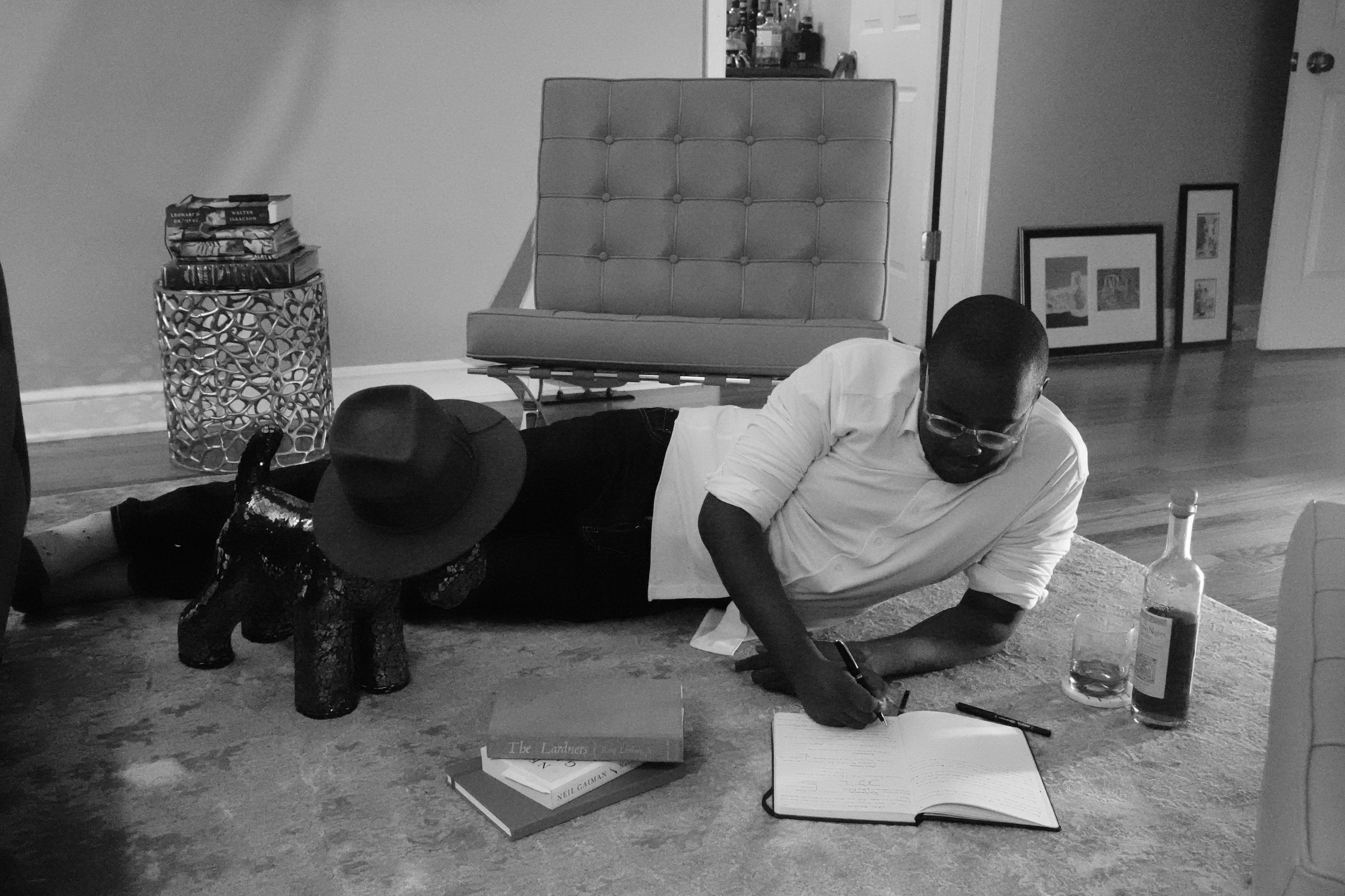 Black and white photo of me on the floor writing.